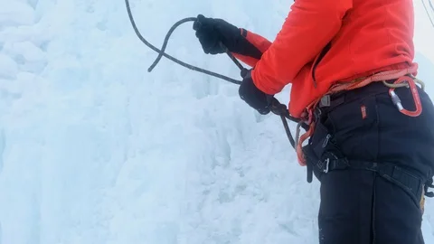 Climber tying a knot on a rope. Ice climbing insurance with ice tools axe 스톡 동영상 128566271