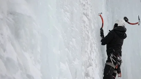 Climber using ice axe to climb on snowy slope of mountain 動画素材 73621842