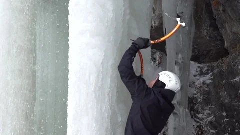Climber using ice axe to climb on snowy mountain in slow motion Stock Footage 73622473