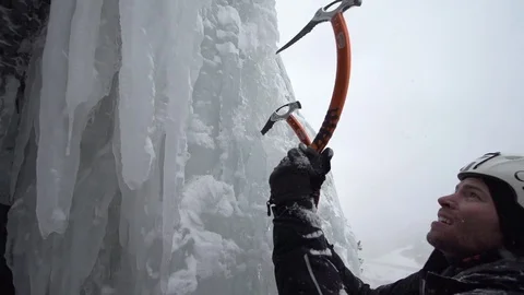 Climber using ice axe to climb on snowy mountain in slow motion Stock Footage 73622855