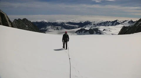 Climber walking across snow covered mountain top Stock Footage 55539338
