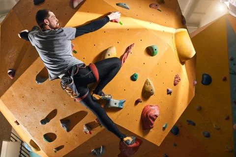 Climber without forearm training at the hardest artificial wall in bouldering Stock Photos