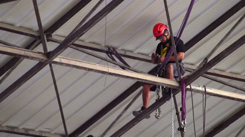 Climber worker is installing some lights in roof Stock Footage 132414005