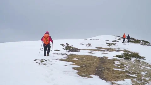 Climbers make final ascent to summit of mountain with snow and patches of Video stock 253389481