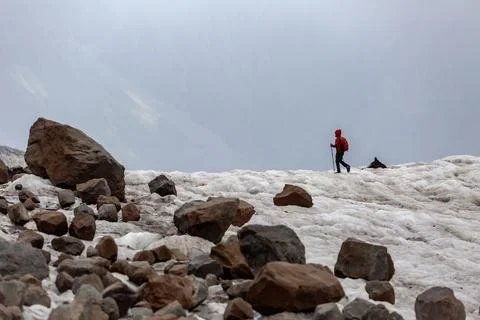 Climbers navigate the steep icy path on Kazbek, where layers of rock and sn.. Stock Photos