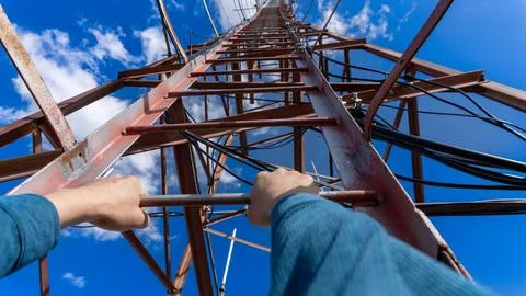 Climbing a communication tower with a view from first-person perspective Stock Photos