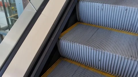 Climbing up an escalator while standing on the steps in a large shopping mall Stock Footage 311879723