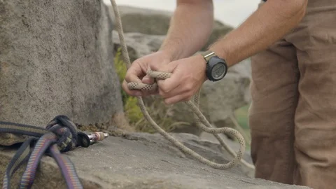Climbing instructor securing a rope to a boulder Stock Footage 97705979