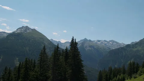 Climbing up the mountain, behind the trees, landscape panorama of Alps Stock Footage 217384468
