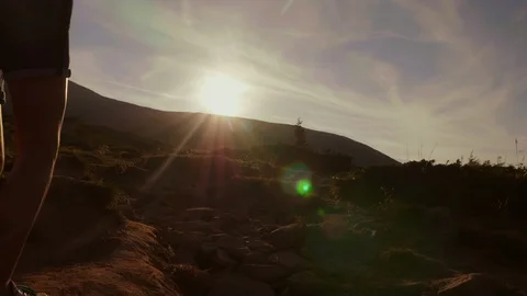 Climbing the mountain at dawn. Two tourists climb up the mountain path in the Stock Footage 90217659