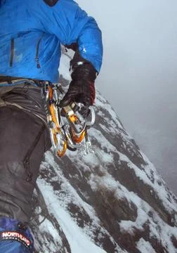  climbing on a mountain on snowy winter day, outdoor sports climbing on a ... Stock Photos