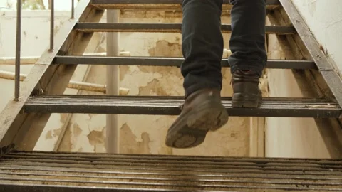 Climbing a stairs, low angle shot. Following some feet that go up a concrete Stock Footage 167708545