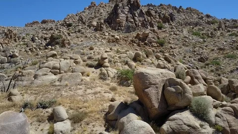 Climbing steep mountain over desolate rock outcroppings, arid California desert Stock Footage 114087100