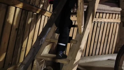 Climbing steps inside a rustic wooden building in the evening light Stock Footage 330188359