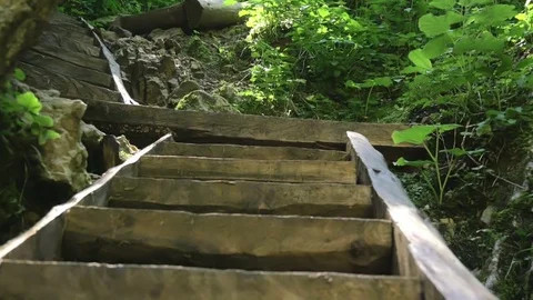 Climbing wooden stairs on hill slope between rocks Stock Footage