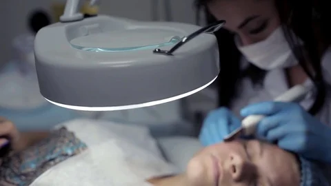 In the clinic, the cosmetologist does the client a mechanical facial cleansing Stock Footage 81637276