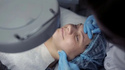In the clinic, the cosmetologist does the client a mechanical facial cleansing Stock Footage 81637368