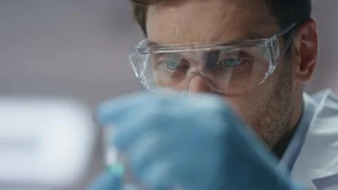 Clinic worker analyzing sample experimental substance in test tube close up. Stock Photos