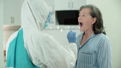 Clinic worker taking swab sample from patient at home, hospital service, test Stock Footage 146392538