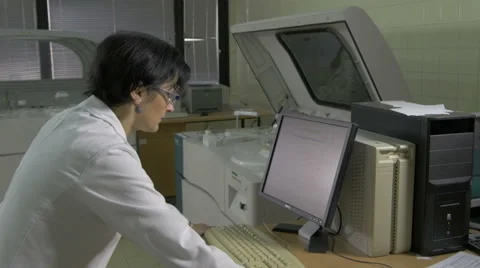 Clinical laboratory assistant loading data on computer machine, blood testing Stock Footage 58994825