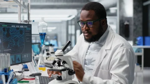 Clinical microbiologist uses microscope for sample observation using PC software Stock Footage 320143417