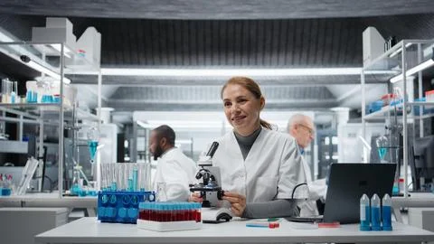 Clinical microbiologist using compound microscope for detailed cellular analysis Stock Photos