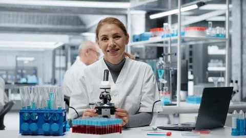 Clinical microbiologist using compound microscope for detailed cellular analysis Stock Photos