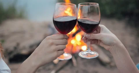 To clink glasses on the background of the campfire Stock Footage 135613163