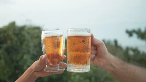 Clinking beer glasses at sunset man and woman hands only Stock-Footage 124769481