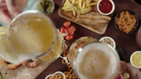 Clinking with frothy beer in glasses top view. Traditional German Cuisine Stock Footage 159502839