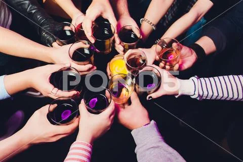 Clinking glasses with alcohol and toasting, party. Congratulations to the event Stock Photos