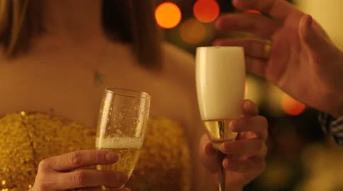 Clinking Glasses by the Christmas Tree Stock Footage 57749188