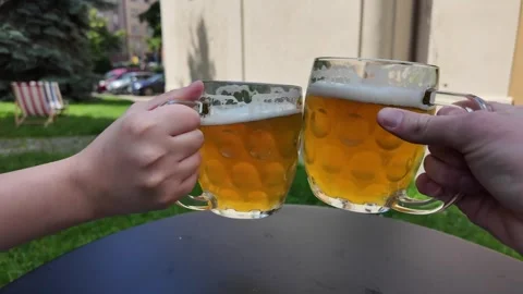 Clinking Glasses, Two Beer Mugs of Czech Pilsner Style Lager in a Cheers Motion Stock Footage 277905567
