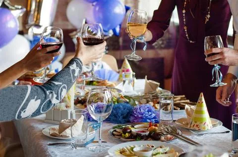 Clinking glasses with white and red wine and toasting. Stock Photos