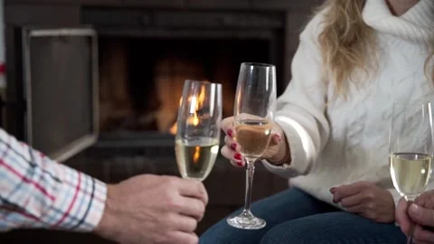 Clinking wine glasses by the fireplace Stock Footage 228069492