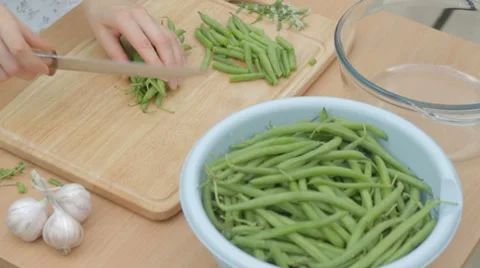 CLIP EDIT Chopping string green beans into three parts on wooden board Stock Footage 8366711