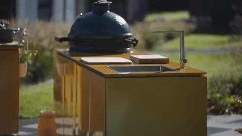 Clip of a large black covered grill on a table in the open air kitchen Stock Footage 247054708