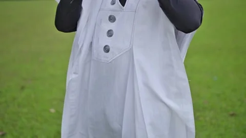 A clip of the mid-section of a dark skinned male raising his sunglasses . Video stock 283985170