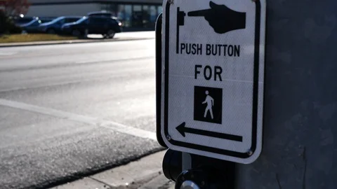 Clip of a "Push Button To Cross" sign while panning. Shot in 4k Stock Footage 98997192
