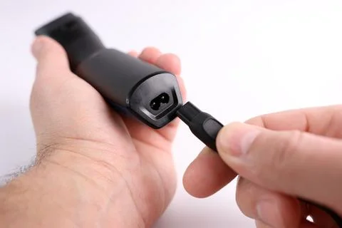 The clipper is connected to the power cable. The concept of household elect.. Stock Photos