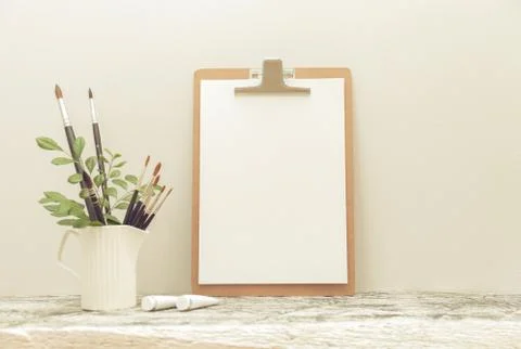 The clipping board mock up on the white table and Art brushes. with haze effect Stock Photos