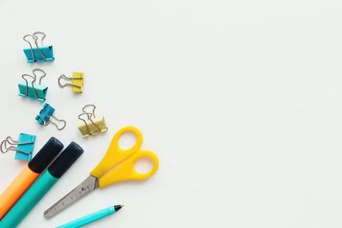 Clips, pencil, marker, scissors, white background. Work and education concept Stock Photos