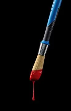 Cloae-up two-colored paintbrus whith red paintdrop on a black background. Stock Photos