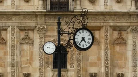Clock against baroque bulding and people walking. Zoom out - Zoom in. Time Lapse Stock Footage