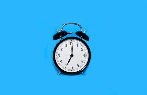 Clock alarm clock on a bright blue background Stock Photos