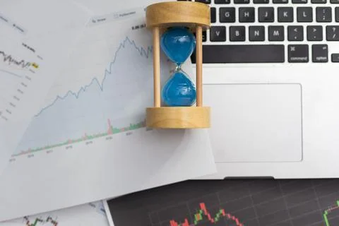 Clock alarm with stock graph chart in laptop screen background.Time,stock market Foto stock