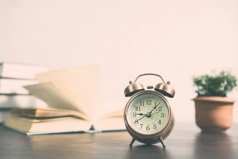 Clock and books on table for time to learning and knowledge concept Fotos de archivo