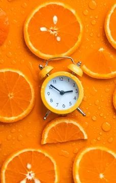 Clock and citruses summer time concept. Selective focus. Stock Photos