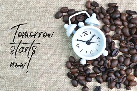 Clock and coffee beans with text TOMORROW STARTS NOW! Stock Photos