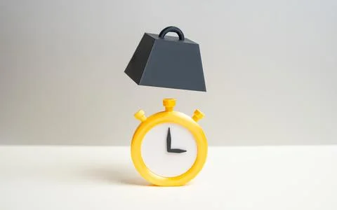 A clock and a falling weight. Pushing deadlines closer. Pressure and deadline Stock Photos